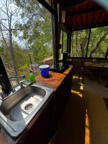 a kitchen with a sink and a counter with a window at Centro Sati Bungalow in Cuatunalco