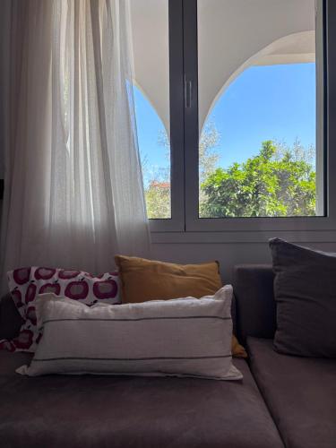 a couch in a room with two windows at Casa Crystallia in Chalkida