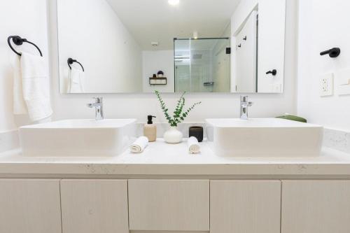 a bathroom with two sinks and a mirror at 2BDR Condo Beach Downtown Jacuzzi Pool Amenities in Cabo San Lucas