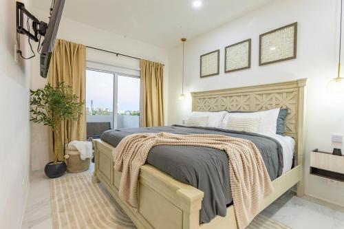 a bedroom with a large bed and a large window at 2BDR Condo Beach Downtown Jacuzzi Pool Amenities in Cabo San Lucas