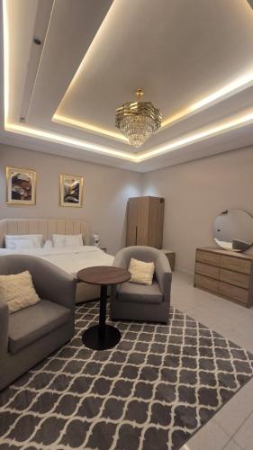 a bedroom with a bed and a couch and a table at ليالي القمر 2 in Sūq ath Thalut