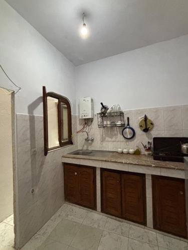a kitchen with a sink and a mirror on the wall at casa chawni in Chefchaouen