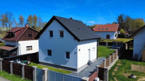 a white house with a black roof at Vila Jesenice in Lipová