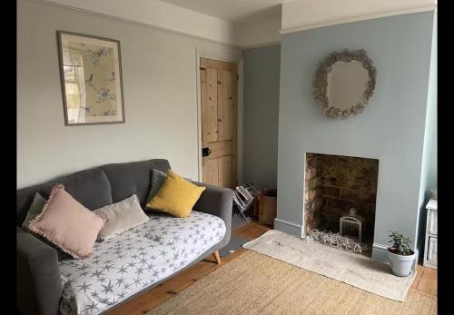 ein Wohnzimmer mit Sofa und Kamin in der Unterkunft Faversham cottage in Kent