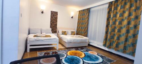 a room with two beds and a table with plates on the floor at Serene Hills Home in Nairobi