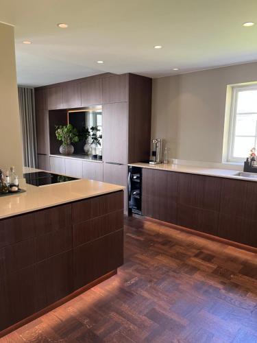 a large kitchen with brown cabinets and a counter top at Spacious, comfortable villa close to lake in Sigtuna