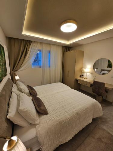 a bedroom with a bed and a desk and a mirror at Malka Suites in Beit Shemesh