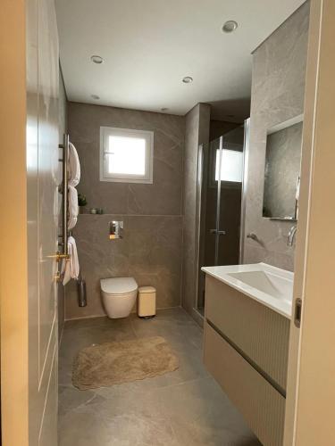 a bathroom with a toilet and a sink at Malka Suites in Beit Shemesh