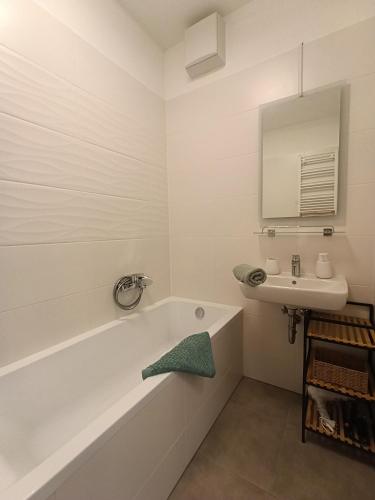 a bathroom with a bath tub and a sink at Szemesbay Serenity Apartman in Balatonszemes