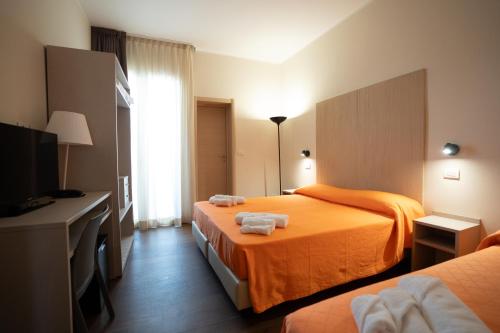 a hotel room with two beds and a television at Hotel Estense in Bellaria-Igea Marina