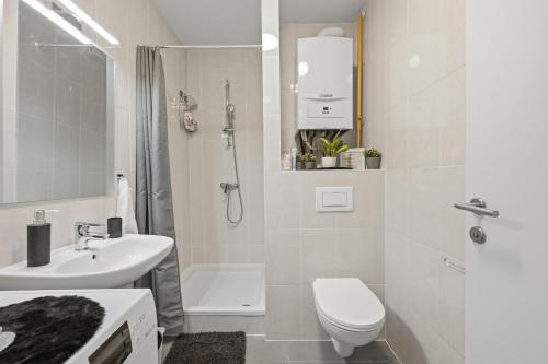 a white bathroom with a toilet and a sink at Apartman Tonka in Šibenik