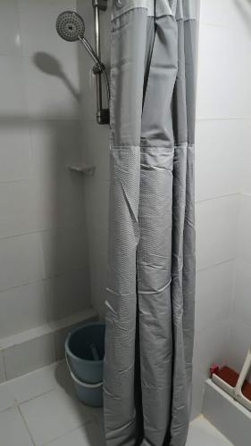 a shower curtain in a bathroom with a blue bucket at Keyspace condotel in Piapi