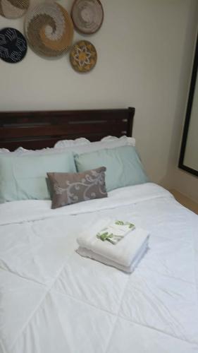 a white bed with two folded towels on it at Keyspace condotel in Piapi