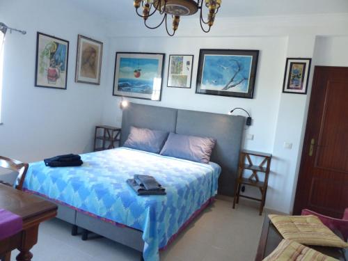 a bedroom with a bed with a blue comforter at Sandra B&B in Luz de Tavira