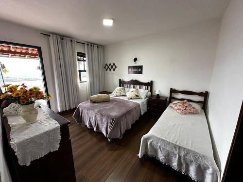 a bedroom with two beds and a vase of flowers at Recanto Divô e Divó in Ouro Preto
