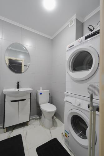 a bathroom with a washing machine and a toilet at Sânzâiana House 3 in Căuşeni