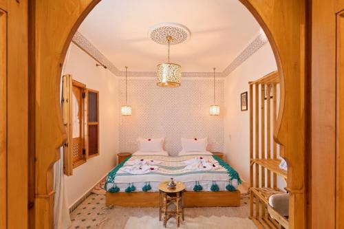 a bedroom with a bed and an archway at Riad Secret De Medina in Marrakesh