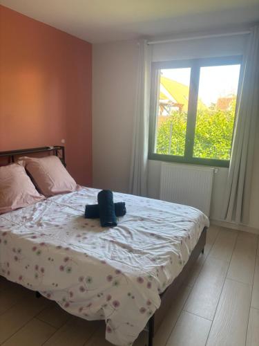 a bedroom with a bed with a hat on it at Au bon moment in Rang-du-Fliers