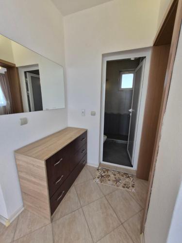 a bathroom with a wooden dresser and a large mirror at Blue Summer in Obzor