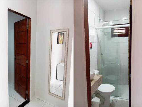 a bathroom with a toilet and a sink and a mirror at Pousada Dunas Beach in Canoa Quebrada