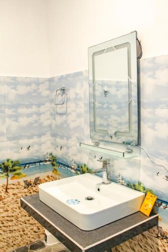 a bathroom with a white sink and a mirror at Bees Honey Cottage Ella in Ella