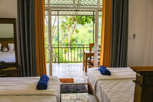 a hotel room with two beds and a balcony at Bees Honey Cottage Ella in Ella