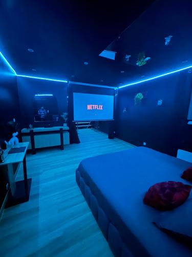 a hotel room with a bed and a television at La nuit nocturne in Bolbec