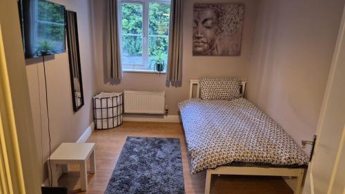 a small room with a bed and a window at Beautiful 2 bed in Wycombe in High Wycombe