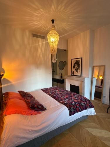 a bedroom with a large bed with a chandelier at Appartement premium Hyper Centre in Ajaccio