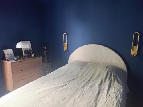 a bedroom with a white bed and a blue wall at Appartement à Anglet in Anglet