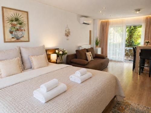 a bedroom with a large bed with two white towels at Orient Apartmanház in Eger