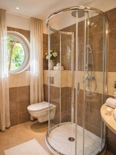 a bathroom with a shower and a toilet at Orient Apartmanház in Eger