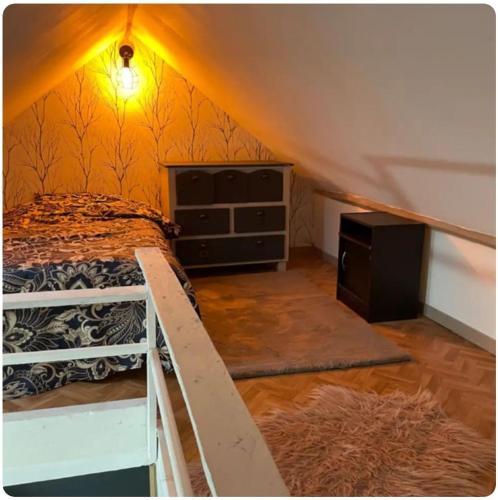 a bedroom with a bed and a dresser in a attic at Maison avec jacuzzi in Vierzon