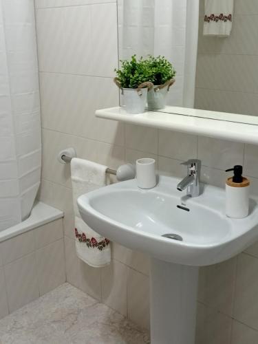 a white bathroom with a sink and a mirror at Cal Pelat Guimerà in Guimerá