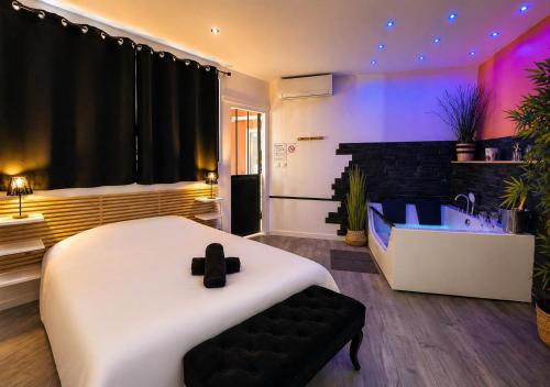 a bedroom with a large bed and a bath tub at Spacieux spa et sauna in Bourges
