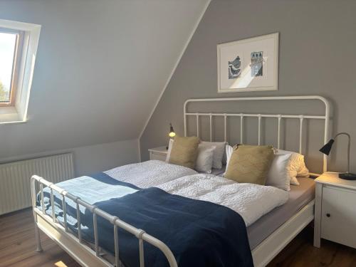 a bedroom with a bed with a blue blanket on it at Kajüthus Apartment 3 in Fehmarn