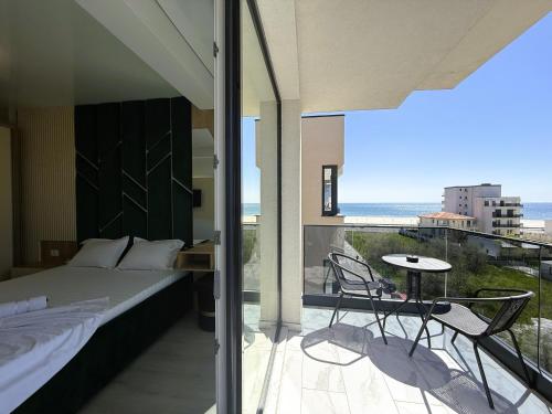 a bedroom with a bed and a balcony with a view at VIBE Apartments in Năvodari