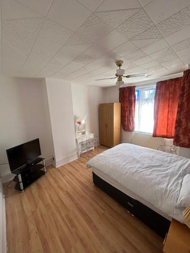 a bedroom with a bed and a flat screen tv at Rehoboth place in Nottingham
