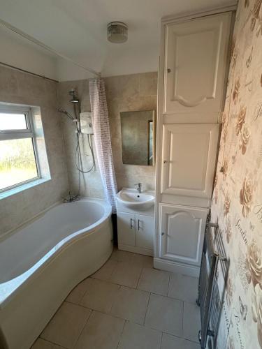 a bathroom with a tub and a sink at Rehoboth place in Nottingham