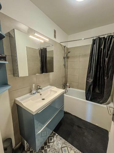 a bathroom with a sink and a tub and a mirror at BayView in Saint-Brieuc