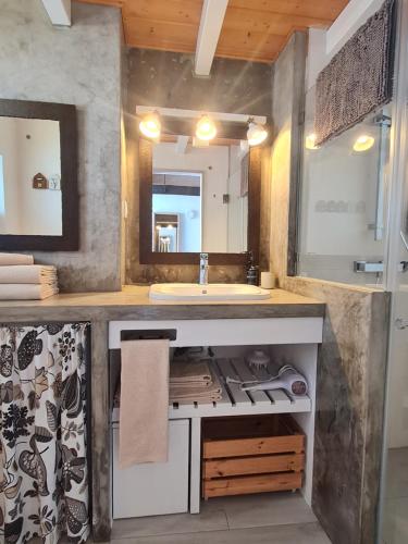 a bathroom with a sink and a large mirror at Alba Odeceixe - casa aurea in Odeceixe