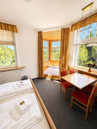 a bedroom with a bed and a table and chairs at Waldgasthaus & Berghotel Steinerne Renne in Wernigerode