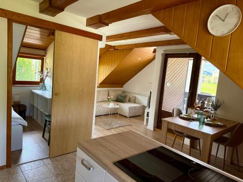 a kitchen and living room with a clock on the wall at Studio Lilly in Bohinj