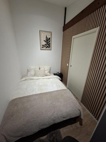 ein Schlafzimmer mit einem weißen Bett und einer großen Tür in der Unterkunft Chalet douceur in Virton