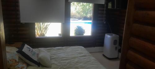 a bedroom with a bed and a window with a pool at Quinta la ponderosa in Brandsen