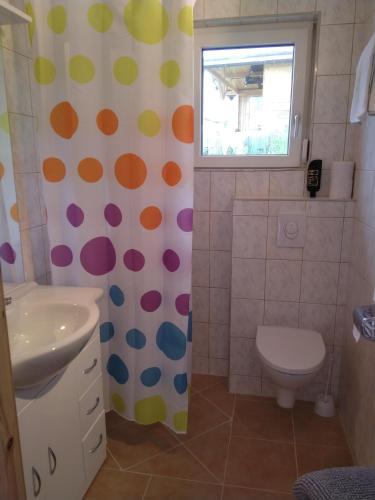 a bathroom with a polka dot shower curtain and a toilet at Haus Orleander in Rehgraben