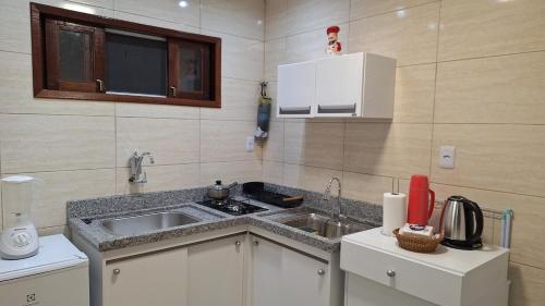 a small kitchen with a sink and a counter at Studio prático e tranquilo em Jacobina in Jacobina