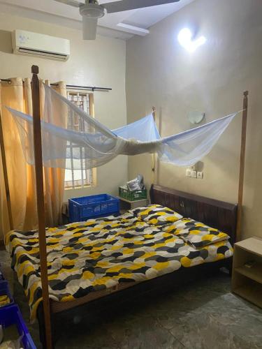 a bedroom with a bed with a mosquito net at Home RÉSIDENCE OUIDAH in Ouidah