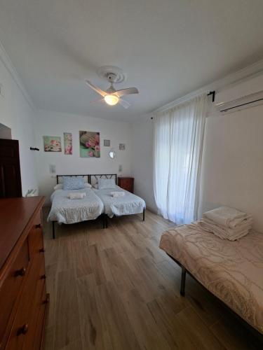 a bedroom with two beds and a ceiling fan at Casa de la abuela Tere Caminito del Rey, Valle de Abdalajís, Málaga in Valle de Abdalagís