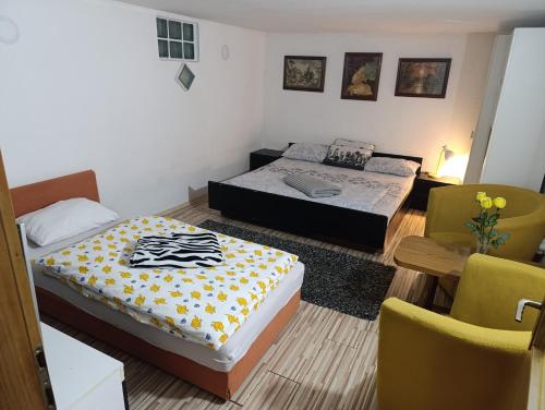 a bedroom with two beds and a table and chairs at Apartman Emma in Visoko